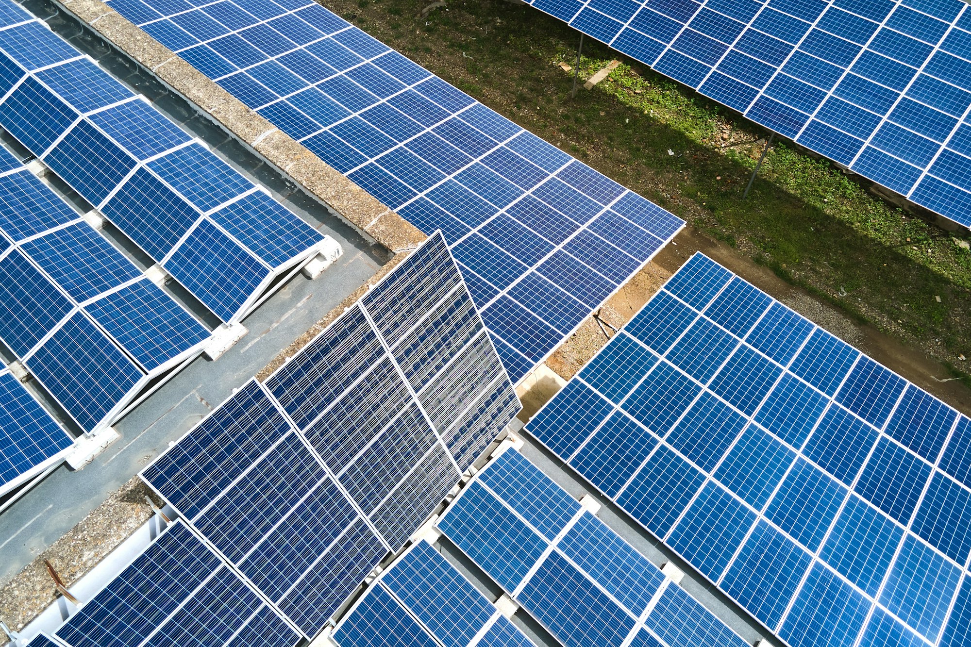 Aerial view of solar power plant with blue photovoltaic panels mounted on industrial building